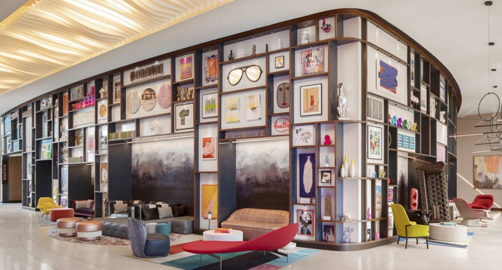 A stylish lounge area with eclectic wall art, modern furniture, and ambient lighting, creating a vibrant and artistic atmosphere.