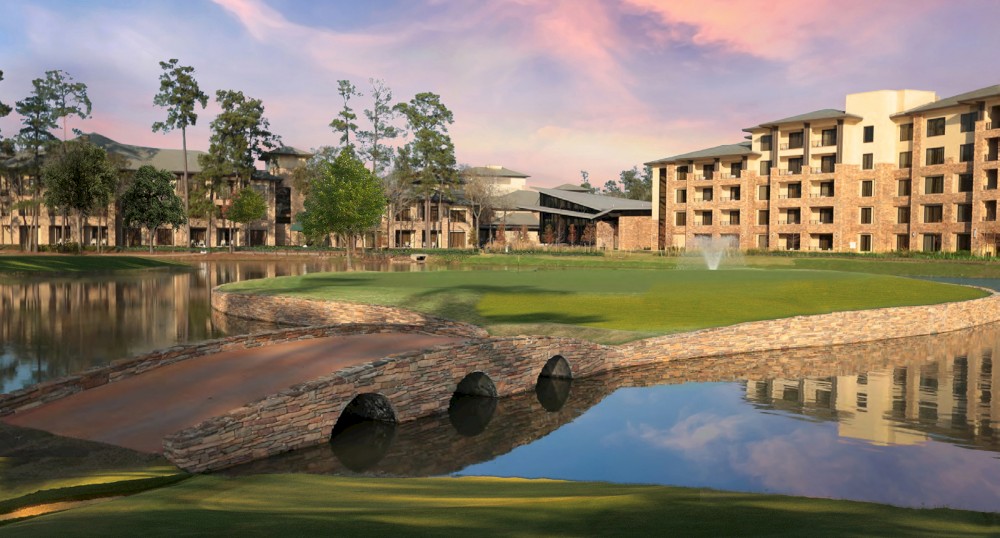 A serene landscape with a stone bridge over water, a pond fountain, trees, a multi-story building, and a colorful sky at sunset.